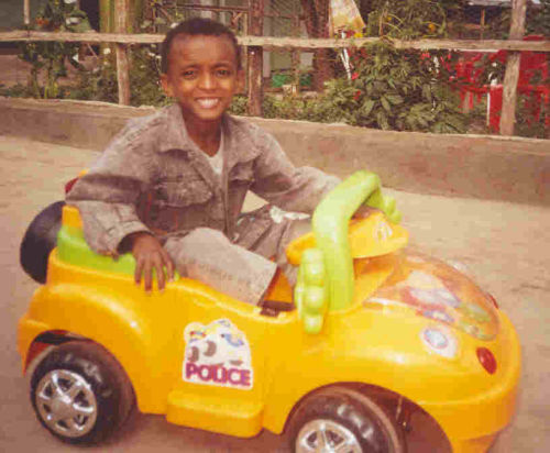 Boy playing with a pedal car