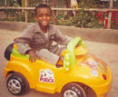 Boy playing with a pedal car