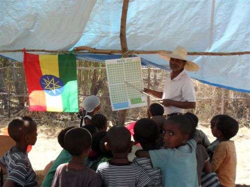 Asenake teaches children to recite the Amharic fidel