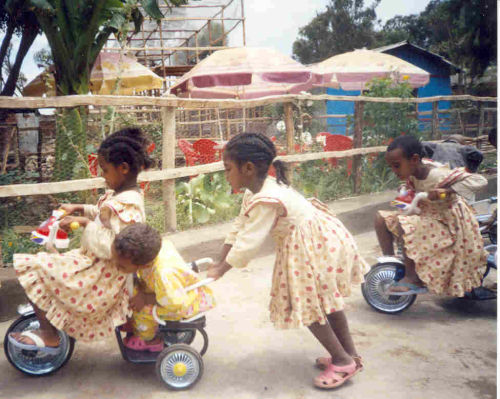 schoolgirls playing on the tricycles