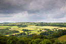 Sunlit Restormel Castle under stormy skies