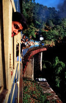Passengers waving from the windows of a train in India