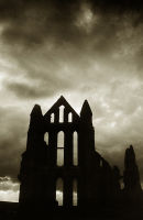 The ruined Abbey silhouetted against a stormy sky