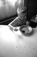 Bacau, Romania. 1994. A child eats soup and bread at an orphanage in this northern city. 