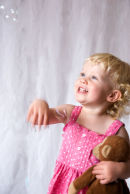 Young girl photographed playing with bubbles at home